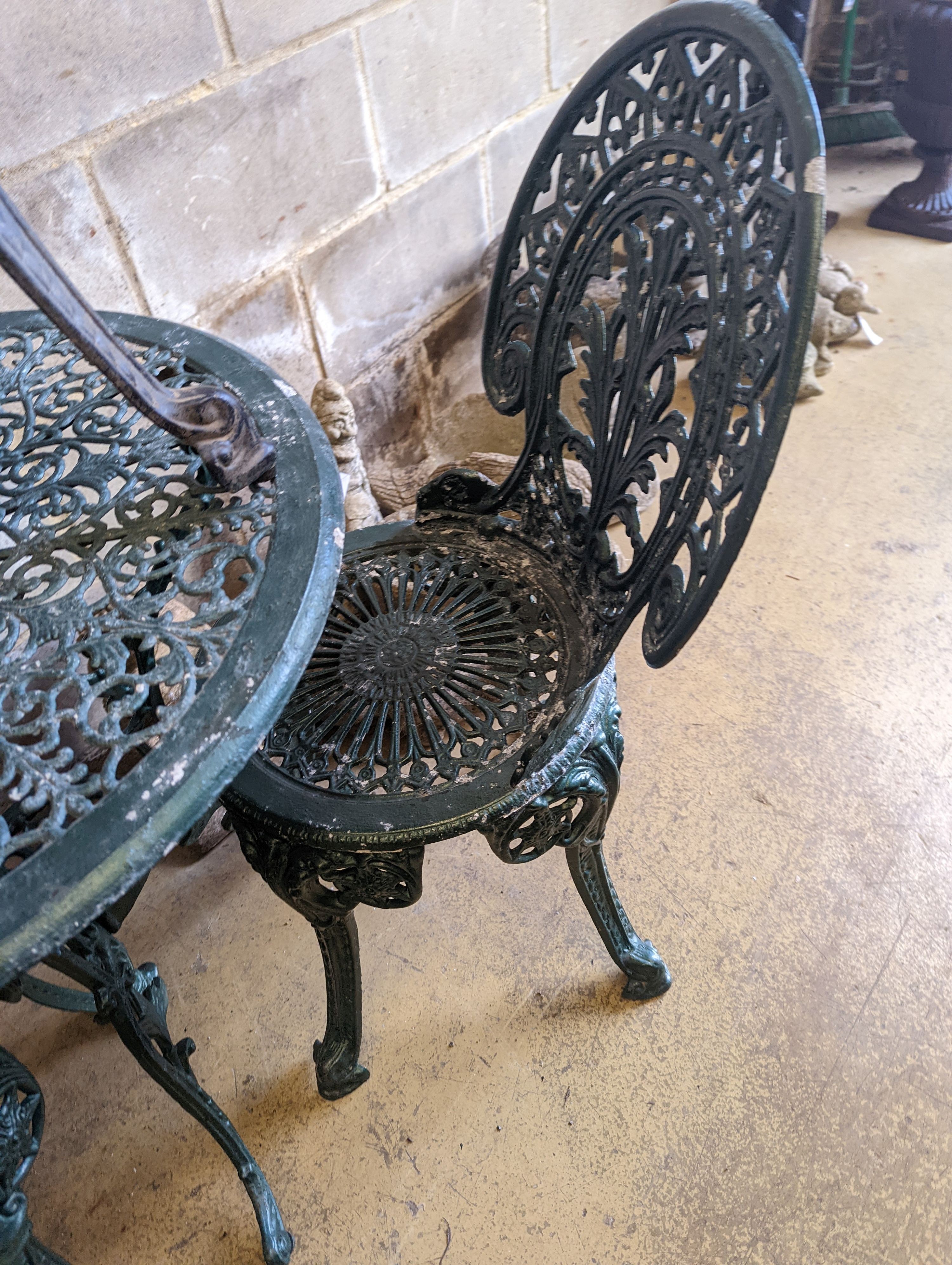 A circular painted aluminium garden table, diameter 65cm, together with three chairs